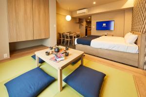 una camera d'albergo con letto e tavolo con sedie di MONday Apart Ueno Shinokachimachi a Tokyo