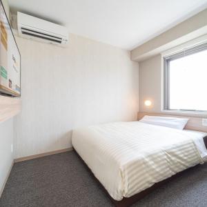 Postel nebo postele na pokoji v ubytování Super Hotel Iyo Saijo