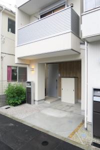 um edifício branco com uma porta em frente em Etranger Kaname Cho em Tóquio