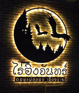 ein Schild mit zwei Vögeln vor einem Mond in der Unterkunft Ing Chan Farm /ไร่อิงจันทร์ in Chiang Rai