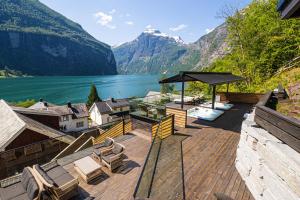 een terras met uitzicht op een meer en de bergen bij Grande Fjord Hotel in Geiranger