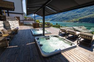 uma banheira de hidromassagem no deque de uma casa em Grande Fjord Hotel em Geiranger