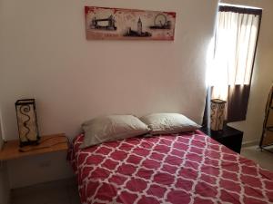 1 dormitorio con 1 cama con edredón morado y blanco en Casa cerca de Estero Beach, en Ensenada