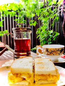 einen Teller mit zwei Sandwiches und einer Tasse Tee in der Unterkunft Guest House Oumi in Kyoto