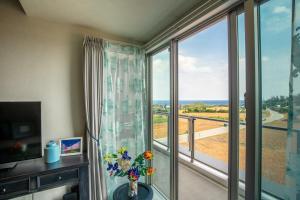 a room with a large window with a view of the ocean at Ocean Resort House 205 in Onna
