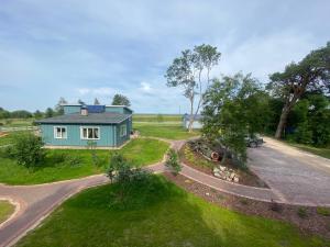 an aerial view of a blue house with a driveway at 2 bedroom house Ragakrasts in Mērsrags