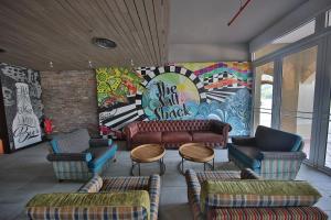 パンタイチェナンにあるリゾーツ ワールド ランカウイのソファと椅子、壁画のあるロビー