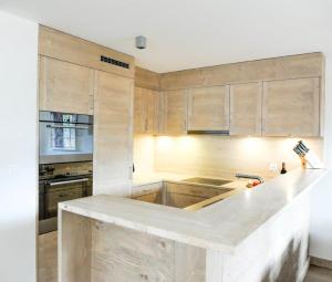 a kitchen with wooden cabinets and a white counter top at Luxury Grimentz Apartment in Grimentz +39 photos