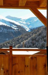 a window in a wooden cabin with a view of a mountain at Luxury Grimentz Apartment in Grimentz
