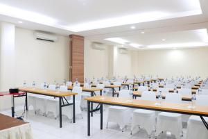 una grande stanza con tavoli e sedie in una stanza di LeGreen Suite Ratulangi a Ambon