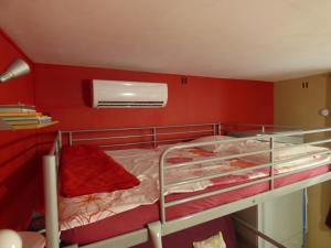 シジャンにあるChez Odileの赤い壁のドミトリールームの二段ベッド1台分です。