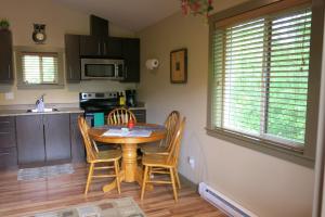 a kitchen with a table and chairs in a room at A Shack In The Woods in Port Renfrew