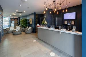 a lobby with a bar with couches and a tv at Narrabeen Sands Hotel by Nightcap Plus in Narrabeen