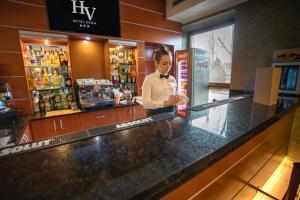 a woman standing behind the counter of a bar at Business Hotel Vega Wrocław in Wrocław
