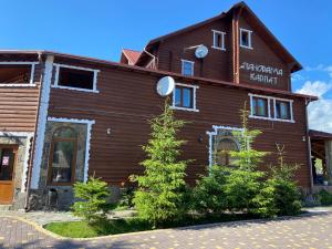 un edificio de madera con árboles delante de él en Panorama Karpat, en Yablunytsya