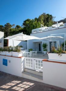 Cette maison blanche dispose d'une terrasse et d'un parasol. dans l'établissement Map Enjoy Rooms, à San Vito Lo Capo