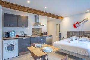 a bedroom with a bed and a table and a kitchen at R’Studio 25 Hyper Centre in Grenoble