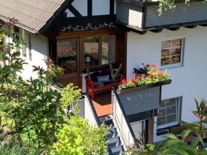 ein Haus mit einer Veranda mit zwei Blumenkästen darauf in der Unterkunft Ferienwohnung Dünnebacke in Schmallenberg