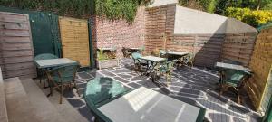 a patio with tables and chairs and a brick wall at Auberge des Remparts in Péronne