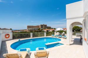 a swimming pool on a balcony with chairs and a swimming pool at Chalet en Calan Forcat in Cala en Forcat