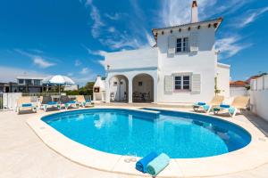 a swimming pool in front of a house at Chalet en Calan Forcat in Cala en Forcat