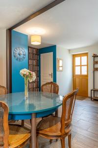 a dining room with a blue table and chairs at Le Meublé MONESTOIS in Mennetou-sur-Cher
