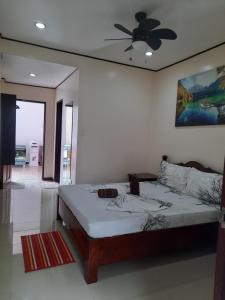 a bedroom with a bed and a ceiling fan at Devayn's Inn in El Nido