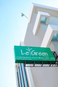 a green sign on the side of a building at LeGreen Suite Waihaong in Ambon