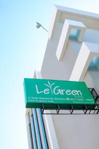 un panneau vert sur le côté d'un bâtiment dans l'établissement LeGreen Suite Waihaong, à Ambon