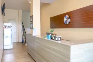 a kitchen with a counter with a clock on the wall at LeGreen Suite Waihaong in Ambon