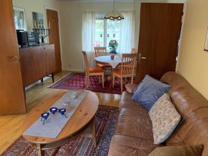 a living room with a leather couch and a table at Almagården lantlig miljö in Svängsta