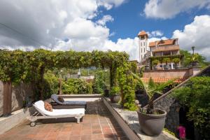 a garden with a pergola and a couch on a patio at Hotel Boutique Casa Isabella in Tepoztl&aacute;n