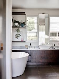 a bathroom with two sinks and a tub and a mirror at Hart's Farm in Shoreham