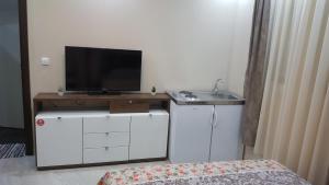 a bathroom with a sink and a television on a counter at Studio apartman - Centar in Tivat