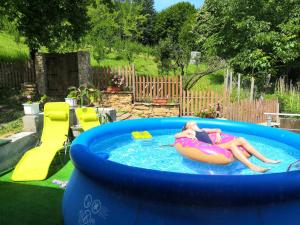 a woman laying on a raft in a swimming pool at Къща за гости ЧИЧАРИТЕ in Gabrovo