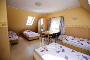 a room with two beds and a table with a tableablish w obiekcie Pokoje Gościnne Via Steso w Gdańsku