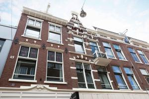 a red brick building with windows on a city street at Anegang Boutique Appartement in Haarlem