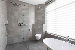 a bathroom with a shower and a toilet and a sink at Anegang Boutique Appartement in Haarlem +10 photos