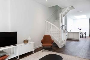 a living room with a staircase and a chair at Anegang Boutique Appartement in Haarlem