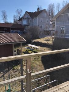 une clôture en bois avec une table de pique-nique et des maisons dans l'établissement Loftet, à Insjön