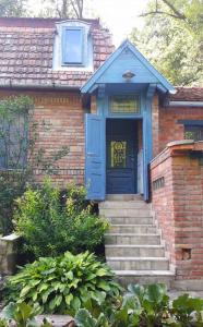 a blue door on a brick house with stairs at Barátkerti Apartman 818 in Szarvaskő