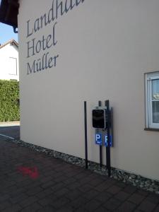 un compteur de stationnement en face d'un bâtiment d'hôtel dans l'établissement Landhaus Hotel Müller, à Ringheim