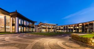 een exterieurbeeld van een gebouw 's nachts bij Pullman Kaifeng Jianye in Kaifeng