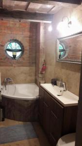 a bathroom with a tub and a sink and a mirror at Barátkerti Apartman 818 in Szarvaskő +27 photos