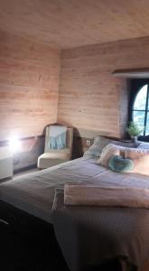 ein Schlafzimmer mit einem großen Bett und einem Stuhl in der Unterkunft Barátkerti Apartman 818 in Szarvaskő