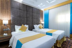 two beds in a hotel room with blue walls at فندق بلاتينيوم الفندقية Platinum Hotel in Al Madinah +52 photos