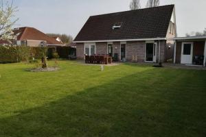 a house with a yard with green grass at Vakantiehuis Horsterwold in Zeewolde