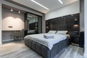 a bedroom with a large bed and a desk at Luxrent Kreshatik Arenacity SkyBar in Kyiv