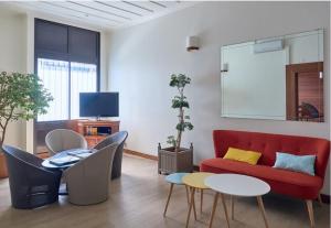 uma sala de estar com um sofá vermelho e cadeiras em Hotel Austral em Saint-Denis