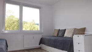 - une chambre blanche avec un lit et 2 fenêtres dans l'établissement Apartmán Pernink, à Pernink